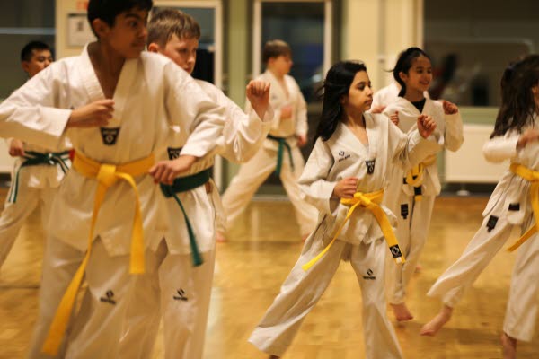 Barn och ungdomar i vita taekwondo-kläder. Foto.
