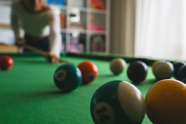 Fyra ungdomar runt ett bordshockeyspel. Foto.