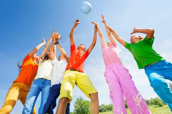Foto:barn som spelar volleyboll i solen: foto
