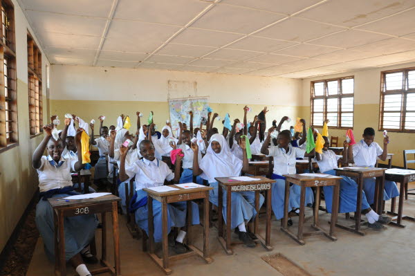 Mörka tjejer i Tanzania som håller upp händerna