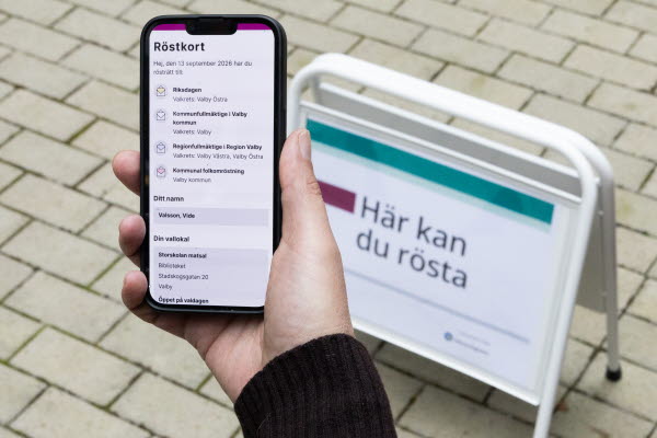 En hand håller i en mobil som visar