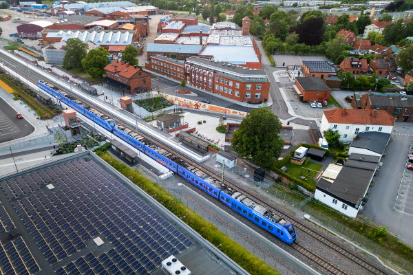 Stationsområdet från ovan med ett pågatåg.Foto.