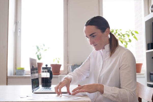 Kvinna framför en bärbar dator. Foto.