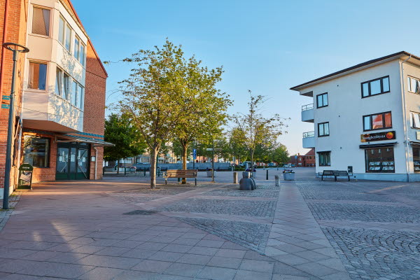 Två flervåningshus med ett torg emellan sig. Foto.