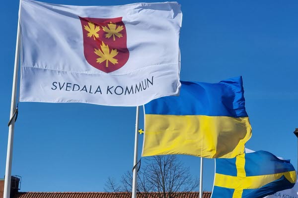 Tre flaggstänger flaggar med Svedala kommuns, Ukrainas och Sveriges flagga. Foto.
