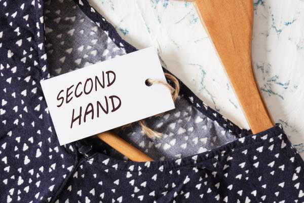 En prickig klänning på en galge, med en lapp som säger "Second Hand". Foto.