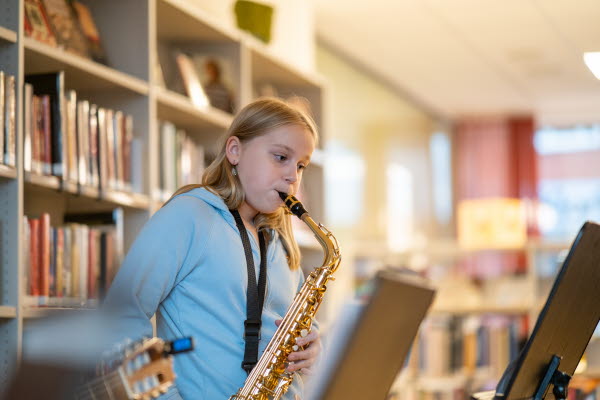 Ett barn spelar på en saxofon. Foto.